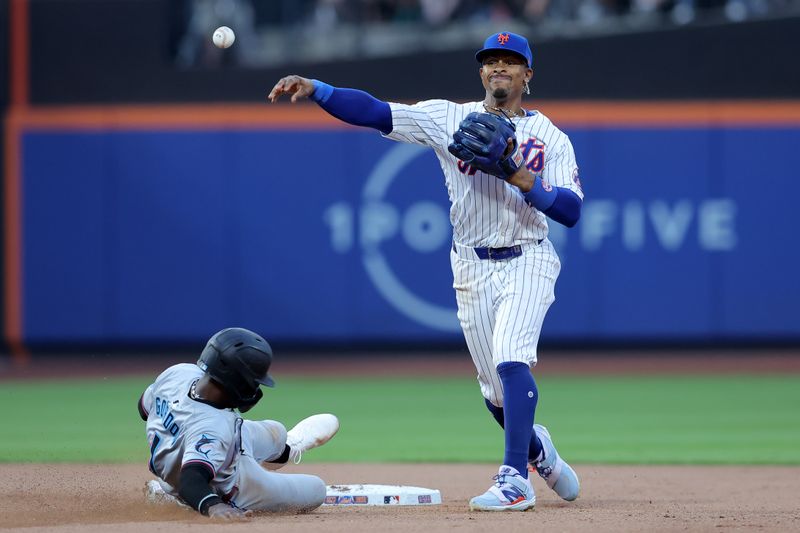 Jun 13, 2024; New York City, New York, USA; New York Mets shortstop Francisco Lindor (12) forces out Miami Marlins left fielder Nick Gordon (1) at second base and throws to first to complete an inning ending double play on a ball hit by Marlins shortstop Tim Anderson (not pictured) during the fourth inning at Citi Field. Mandatory Credit: Brad Penner-USA TODAY Sports