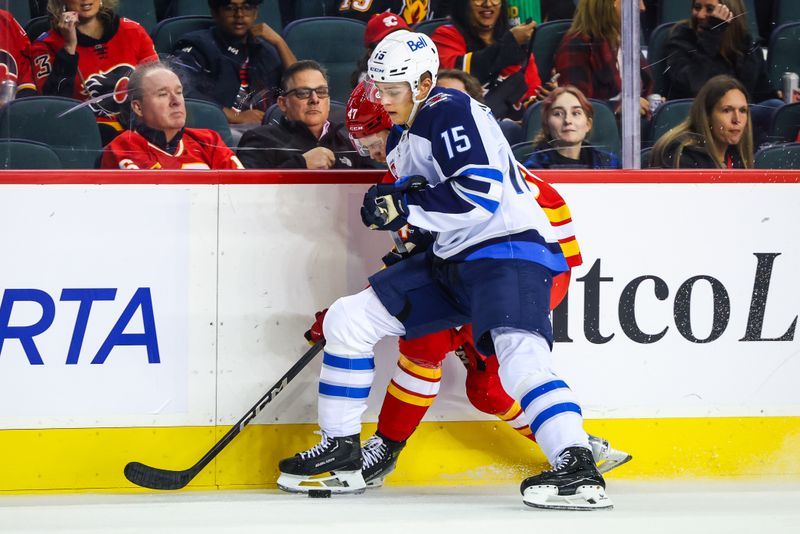 Oct 4, 2024; Calgary, Alberta, CAN; Winnipeg Jets center Rasmus Kupari (15) and Calgary Flames center Connor Zary (47) battles for the puck during the first period at Scotiabank Saddledome. Mandatory Credit: Sergei Belski-Imagn Images