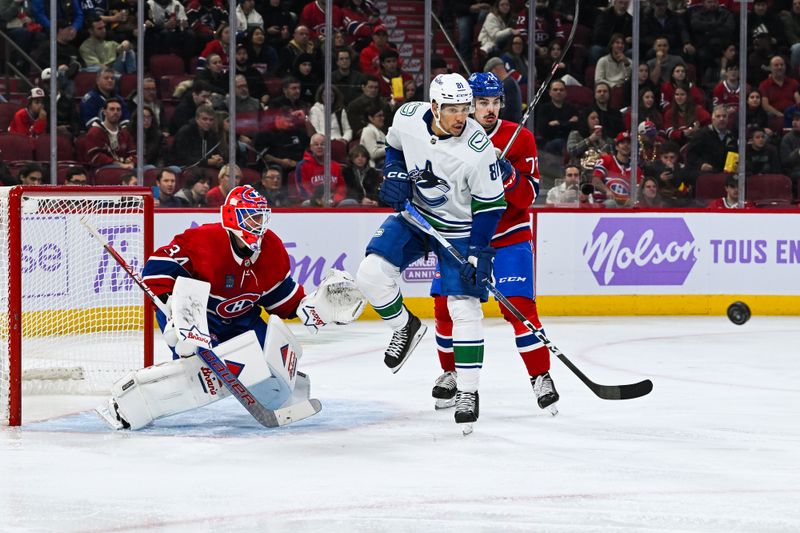 Nov 12, 2023; Montreal, Quebec, CAN; Vancouver Canucks center Dakota Joshua (81) tracks the puck as Montreal Canadiens defenseman Arber Xhekaj (72) defends against him during the third period at Bell Centre. Mandatory Credit: David Kirouac-USA TODAY Sports