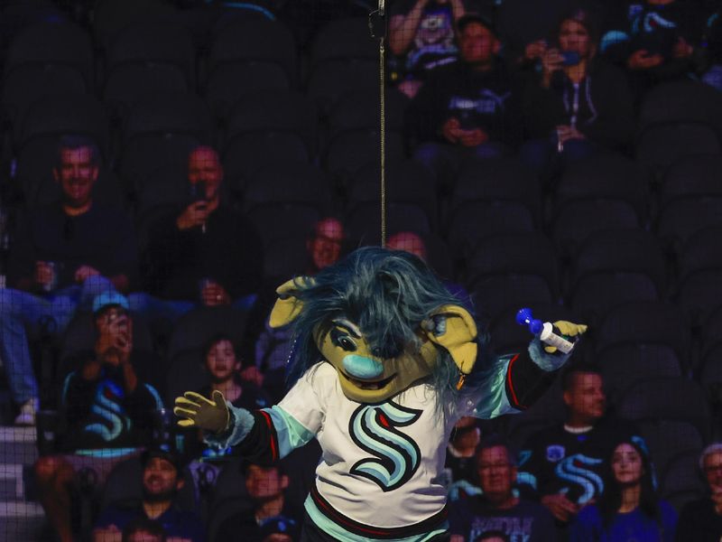 Oct 1, 2022; Seattle, Washington, USA; Seattle Kraken mascot Buoy descends on a cable from the catwalk during his introduction before a game against the Vancouver Canucks at Climate Pledge Arena. Mandatory Credit: Joe Nicholson-USA TODAY Sports