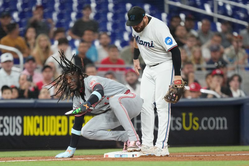 Aug 6, 2024; Miami, Florida, USA;  Cincinnati Reds shortstop Elly De La Cruz (44) steals third base in the third inning as Miami Marlins third baseman Jake Burger (36) looks on at loanDepot Park. Mandatory Credit: Jim Rassol-USA TODAY Sports