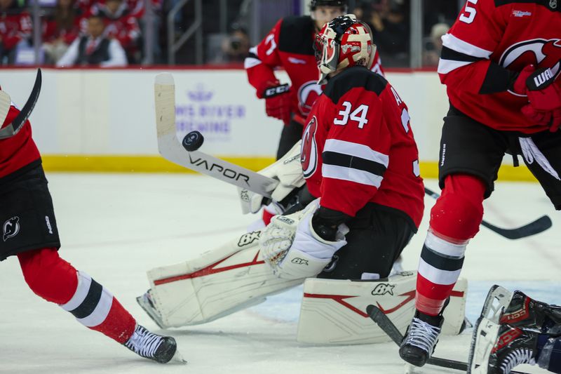 Nov 30, 2024; Newark, New Jersey, USA; New Jersey Devils goaltender Jake Allen (34) stops the puck against the Washington Capitals during the first period at Prudential Center. Mandatory Credit: Thomas Salus-Imagn Images