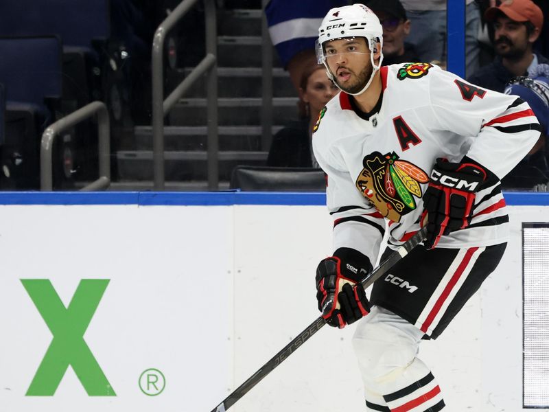 Jan 28, 2025; Tampa, Florida, USA; Chicago Blackhawks defenseman Seth Jones (4) skates with the puck against the Tampa Bay Lightning during the second period at Amalie Arena. Mandatory Credit: Kim Klement Neitzel-Imagn Images