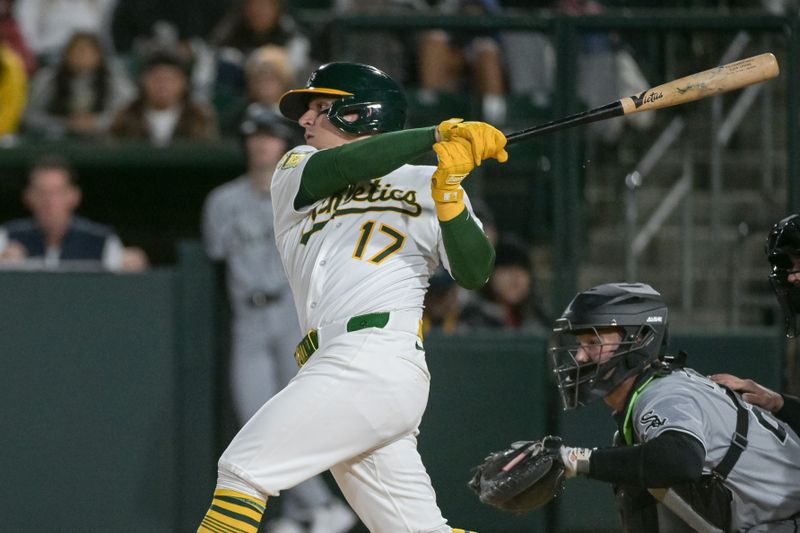 Apr 25, 2025; West Sacramento, California, USA; Athletics third baseman Luis Urías (17) hits a single against the Chicago White Sox during the sixth inning at Sutter Health Park. Mandatory Credit: Ed Szczepanski-Imagn Images