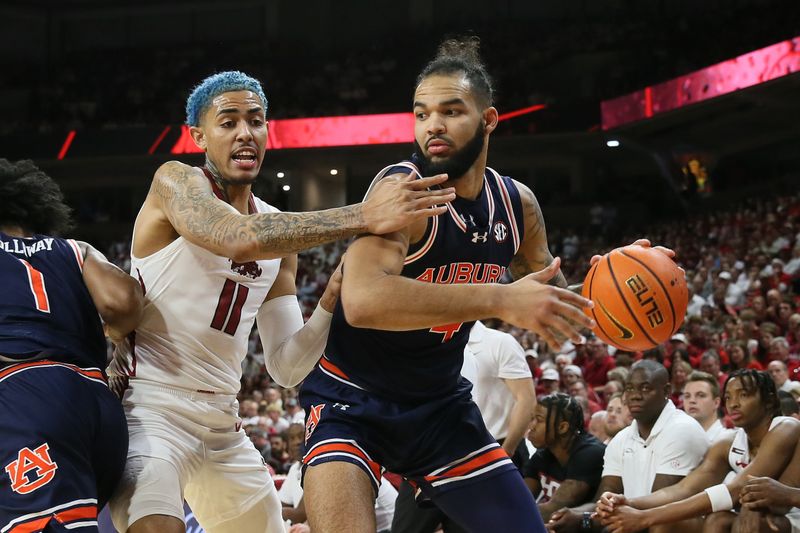 Jan 6, 2024; Fayetteville, Arkansas, USA; Auburn Tigers forward Johni Broome (4) drives against Arkansas Razorbacks forward Jalen Graham (11) during the second half at Bud Walton Arena. Auburn won 83-51. Mandatory Credit: Nelson Chenault-USA TODAY Sports