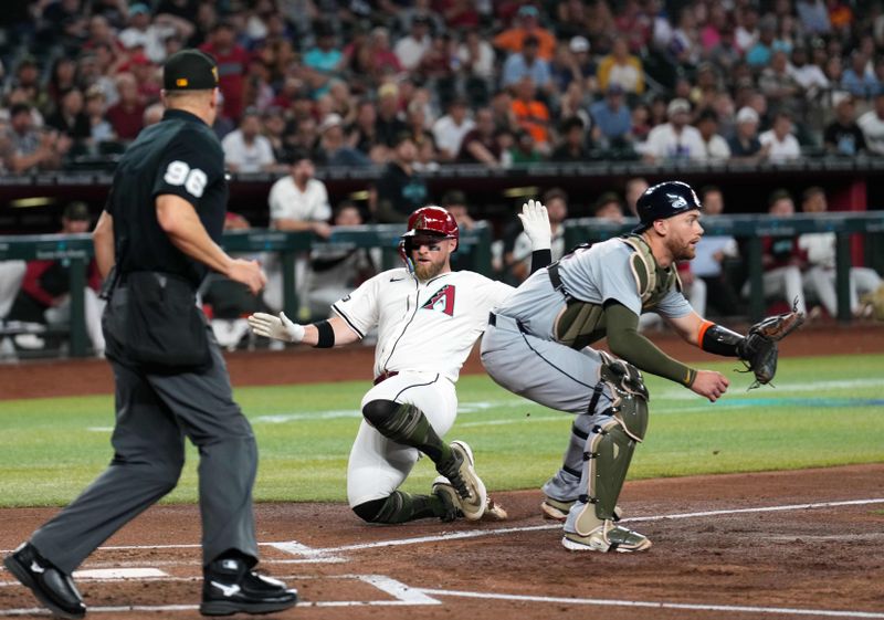 May 19, 2024; Phoenix, Arizona, USA; Arizona Diamondbacks catcher Tucker Barnhart (16) beats a throw to Detroit Tigers catcher Carson Kelly (15) to score a run during the second inning at Chase Field. Mandatory Credit: Joe Camporeale-USA TODAY Sports