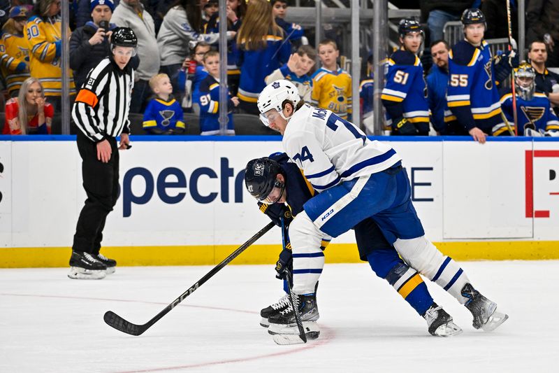 Feb 19, 2024; St. Louis, Missouri, USA;  St. Louis Blues defenseman Torey Krug (47) and Toronto Maple Leafs center Bobby McMann (74) battle for the puck during the third period at Enterprise Center. Mandatory Credit: Jeff Curry-USA TODAY Sports