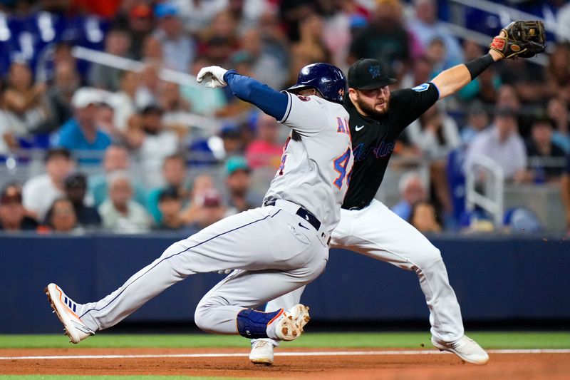 Aug 16, 2023; Miami, Florida, USA; Houston Astros left fielder Yordan Alvarez (44) slides into third base as Miami Marlins third baseman Jake Burger (36) attempts a catch during the fourth inning at loanDepot Park. Mandatory Credit: Rich Storry-USA TODAY Sports