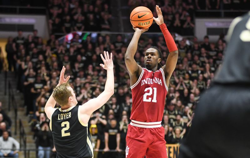 Jan 31, 2025; West Lafayette, Indiana, USA; Indiana Hoosiers forward Mackenzie Mgbako (21) makes a three-point basket over Purdue Boilermakers guard Fletcher Loyer (2) during the first half at Mackey Arena. Mandatory Credit: Robert Goddin-Imagn Images