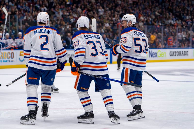 Oct 4, 2024; Vancouver, British Columbia, CAN; Edmonton Oilers defenseman Evan Bouchard (2) and forward Viktor Arvidsson (33) and forward Jeff Skinner (53) celebrate Bouchard’s goal against the Vancouver Canucks during the second period at Rogers Arena. Mandatory Credit: Bob Frid-Imagn Images