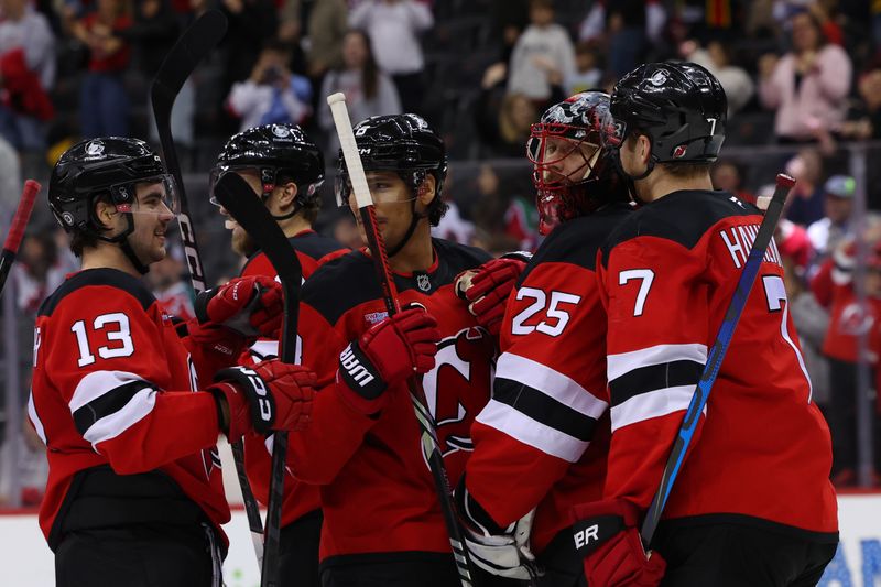 Nov 7, 2024; Newark, New Jersey, USA; New Jersey Devils center Nico Hischier (13), goaltender Jacob Markstrom (25) and defenseman Dougie Hamilton (7) celebrate the Devils win over the Montreal Canadiens at Prudential Center. Mandatory Credit: Ed Mulholland-Imagn Images