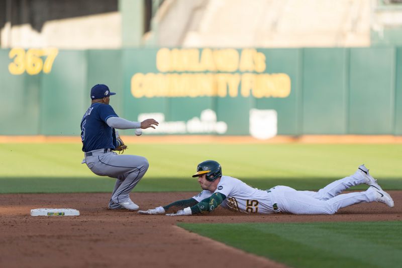 Jun 14, 2023; Oakland, California, USA;  Oakland Athletics left fielder Brent Rooker (25) slides into second base safely during the second inning against Tampa Bay Rays shortstop Wander Franco (5) at Oakland-Alameda County Coliseum. Mandatory Credit: Stan Szeto-USA TODAY Sports