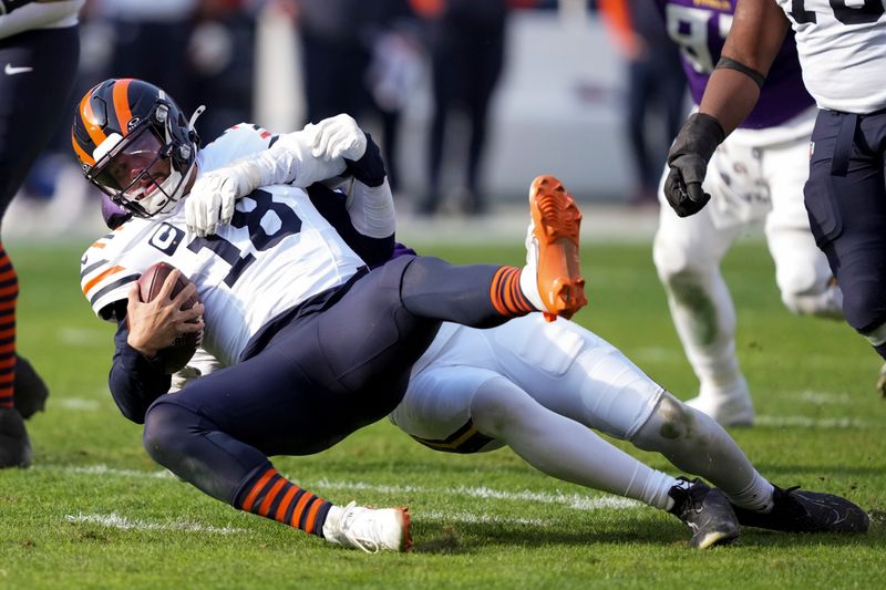 Chicago Bears quarterback Caleb Williams is sacked by Minnesota Vikings linebacker Jonathan Greenard (58) during the first half of an NFL football game Sunday, Nov. 24, 2024, in Chicago. (AP Photo/Charles Rex Arbogast)