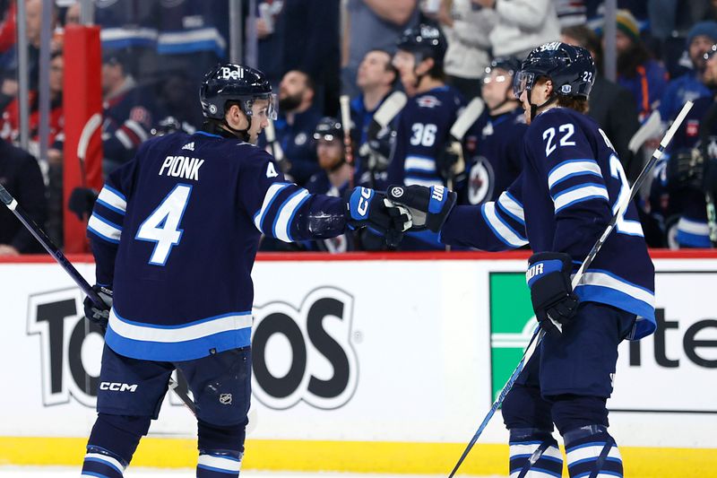 Mar 11, 2024; Winnipeg, Manitoba, CAN; Winnipeg Jets defenseman Neal Pionk (4) celebrates his first period goal with center Mason Appleton (22) against the Washington Capitals at Canada Life Centre. Mandatory Credit: James Carey Lauder-USA TODAY Sports