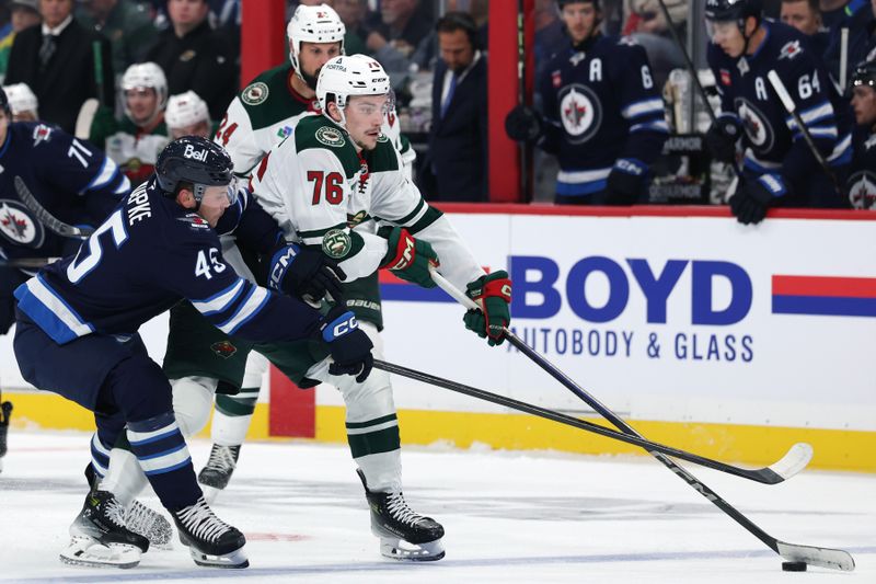 Sep 21, 2025; Winnipeg, Manitoba, CAN; Winnipeg Jets left wing Cole Koepke (45) stick checks Minnesota Wild center Caedan Bankier (76) during the second period at Canada Life Centre. Mandatory Credit: James Carey Lauder-Imagn Images