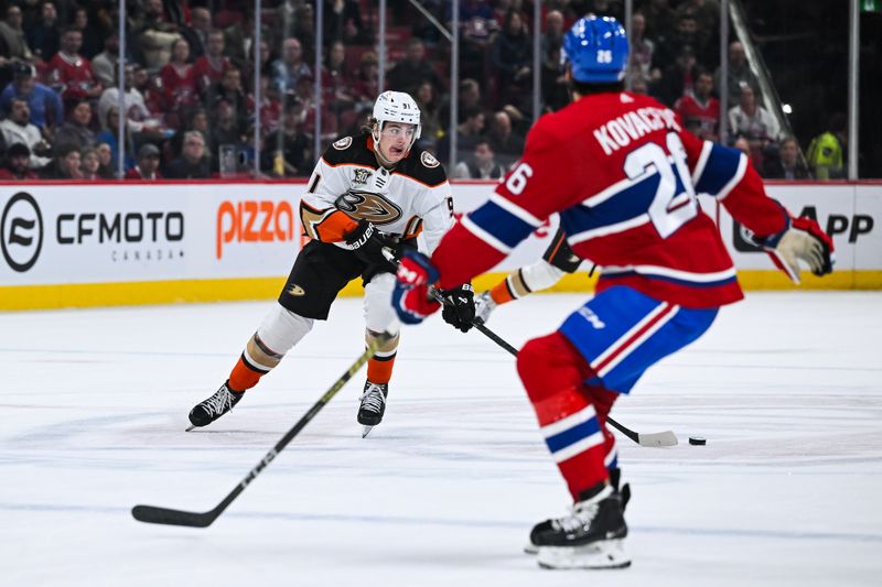 Feb 13, 2024; Montreal, Quebec, CAN; Anaheim Ducks center Leo Carlsson (91) plays the puck against Montreal Canadiens defenseman Johnathan Kovacevic (26) during the first period at Bell Centre. Mandatory Credit: David Kirouac-USA TODAY Sports