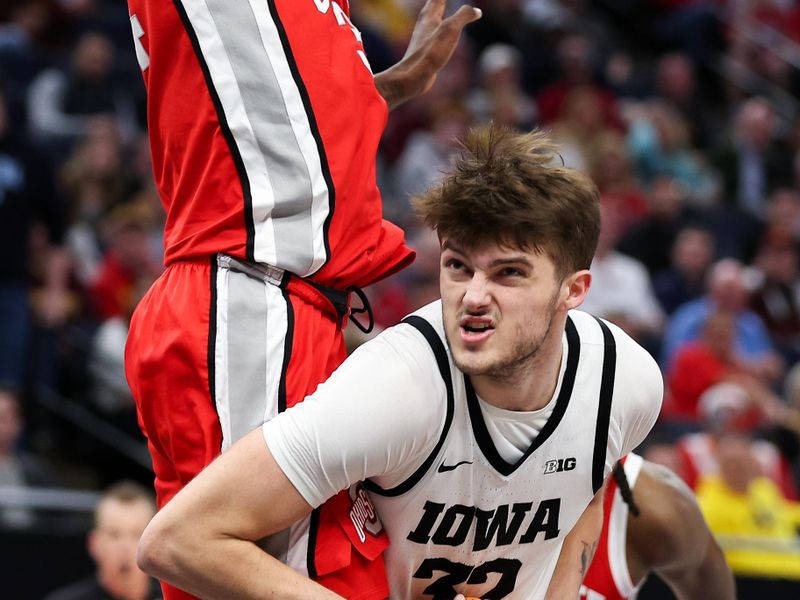 Mar 14, 2024; Minneapolis, MN, USA; Iowa Hawkeyes forward Owen Freeman (32) shoots as Ohio State Buckeyes center Felix Okpara (34) defends during the first half at Target Center. Mandatory Credit: Matt Krohn-USA TODAY Sports