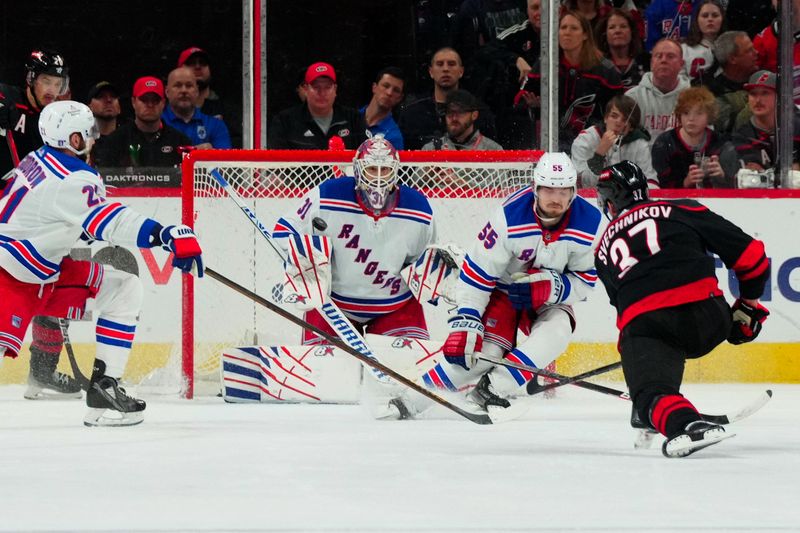 May 11, 2024; Raleigh, North Carolina, USA; Carolina Hurricanes right wing Andrei Svechnikov (37) shoots the puck against New York Rangers defenseman Ryan Lindgren (55) and goaltender Igor Shesterkin (31) during the second period in game four of the second round of the 2024 Stanley Cup Playoffs at PNC Arena. Mandatory Credit: James Guillory-USA TODAY Sports