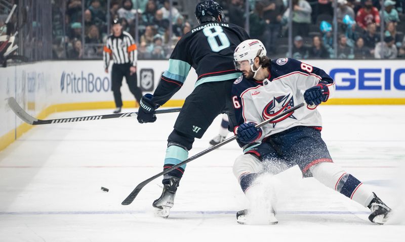 Jan 28, 2024; Seattle, Washington, USA; Columbus Blue Jackets forward Kirill Marchenko (86) battles Seattle Kraken defenseman Brian Dumoulin (8) for the puck during the first period at Climate Pledge Arena. Mandatory Credit: Stephen Brashear-USA TODAY Sports