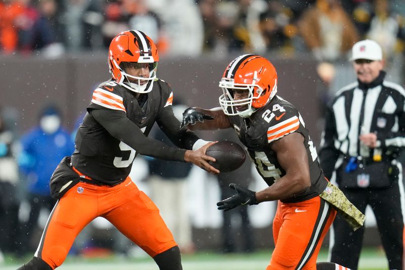 Cleveland Browns quarterback Jameis Winston (5) hands off to running back Nick Chubb (24) in the first half of an NFL football game against the Pittsburgh Steelers, Thursday, Nov. 21, 2024, in Cleveland. (AP Photo/Sue Ogrocki)