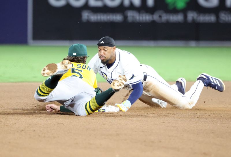 Jun 30, 2025; Tampa, Florida, USA;  Tampa Bay Rays outfielder Chandler Simpson (14) slides safe into second base as he steals and Athletics shortstop Jacob Wilson (5) attempts to tag him out during the eighth inning at George M. Steinbrenner Field. Mandatory Credit: Kim Klement Neitzel-Imagn Images