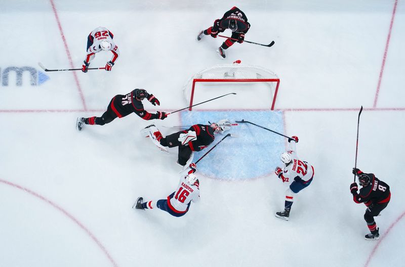 Nov 3, 2024; Raleigh, North Carolina, USA;  Washington Capitals right wing Brandon Duhaime (22) scores a goal past Carolina Hurricanes goaltender Pyotr Kochetkov (52) during the first period at Lenovo Center. Mandatory Credit: James Guillory-Imagn Images