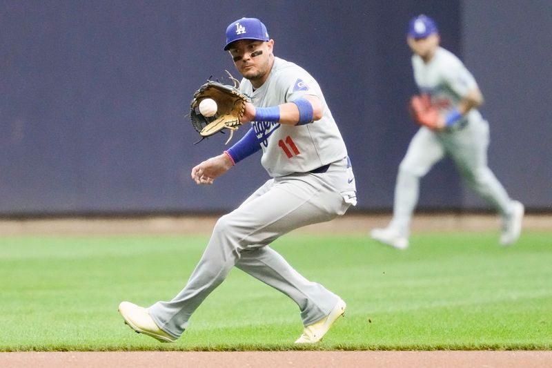 Aug 13, 2024; Milwaukee, Wisconsin, USA;  Los Angeles Dodgers shortstop Miguel Rojas (11) fields the ball during the first inning against the Milwaukee Brewers at American Family Field. Mandatory Credit: Jeff Hanisch-USA TODAY Sports