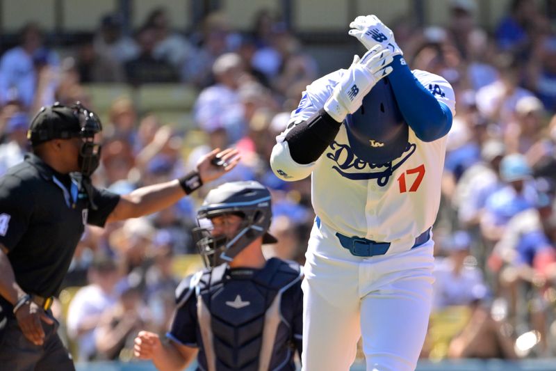 Aug 25, 2024; Los Angeles, California, USA;  Los Angeles Dodgers designated hitter Shohei Ohtani (17) clutches his wrist as he runs to first base after he was hit by a pitch in the eighth inning against the Tampa Bay Rays at Dodger Stadium. Mandatory Credit: Jayne Kamin-Oncea-USA TODAY Sports