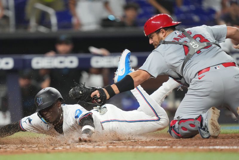 Jun 17, 2024; Miami, Florida, USA;  St. Louis Cardinals catcher Pedro Pagés (43) tags out Miami Marlins left fielder Nick Gordon (1) at home plate in the 12th inning at loanDepot Park. Mandatory Credit: Jim Rassol-USA TODAY Sports