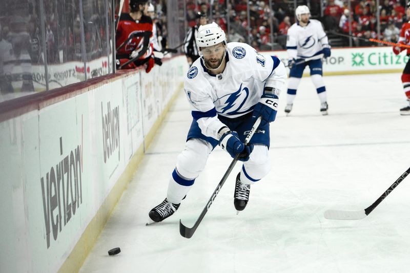 Feb 25, 2024; Newark, New Jersey, USA; Tampa Bay Lightning center Luke Glendening (11) skates with the puck while being defended by during the third period against the New Jersey Devils at Prudential Center. Mandatory Credit: John Jones-USA TODAY Sports