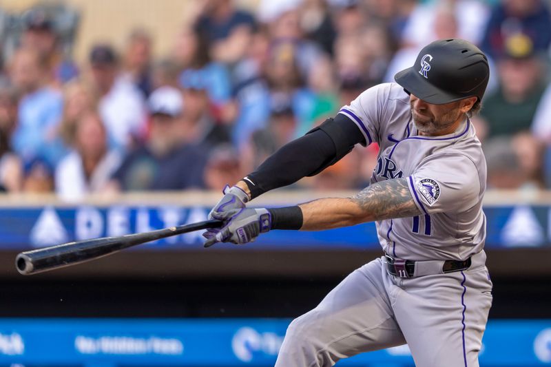 Jun 10, 2024; Minneapolis, Minnesota, USA; Colorado Rockies left fielder Jake Cave (11) hits a single against the Minnesota Twins in the first inning at Target Field. Mandatory Credit: Jesse Johnson-USA TODAY Sports