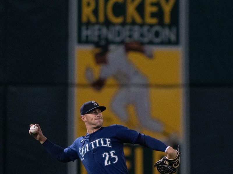 Sep 18, 2023; Oakland, California, USA;  Seattle Mariners left fielder Dylan Moore (25) throws the ball during the fourth inning against the Oakland Athletics at Oakland-Alameda County Coliseum. Mandatory Credit: Stan Szeto-USA TODAY Sports