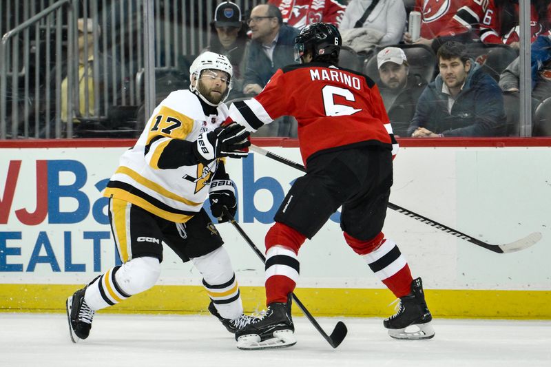Apr 2, 2024; Newark, New Jersey, USA; Pittsburgh Penguins right wing Bryan Rust (17) tries to skate past New Jersey Devils defenseman John Marino (6) during the first period at Prudential Center. Mandatory Credit: John Jones-USA TODAY Sports