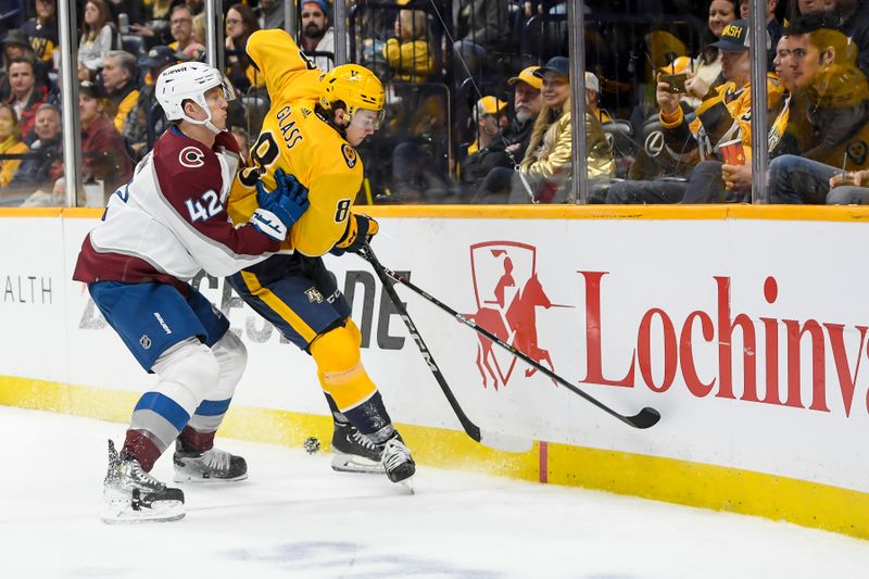 Nov 20, 2023; Nashville, Tennessee, USA;  Colorado Avalanche defenseman Josh Manson (42) and  Nashville Predators center Cody Glass (8) fight for the puck during the third period at Bridgestone Arena. Mandatory Credit: Steve Roberts-USA TODAY Sports