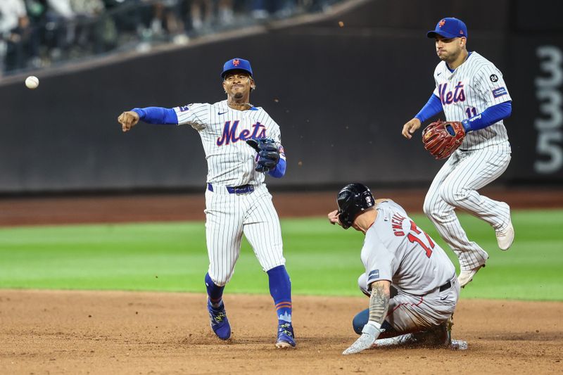 Sep 3, 2024; New York City, New York, USA;  New York Mets shortstop Francisco Lindor (12) throws past Boston Red Sox right fielder Tyler O'Neill (17) attempting to complete a double play in the eighth inning against the Boston Red Sox at Citi Field. Mandatory Credit: Wendell Cruz-Imagn Images