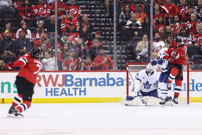 Oct 10, 2024; Newark, New Jersey, USA; Toronto Maple Leafs goaltender Dennis Hildeby (35) makes a save on New Jersey Devils defenseman Dougie Hamilton (7) during the third period at Prudential Center. Mandatory Credit: Ed Mulholland-Imagn Images