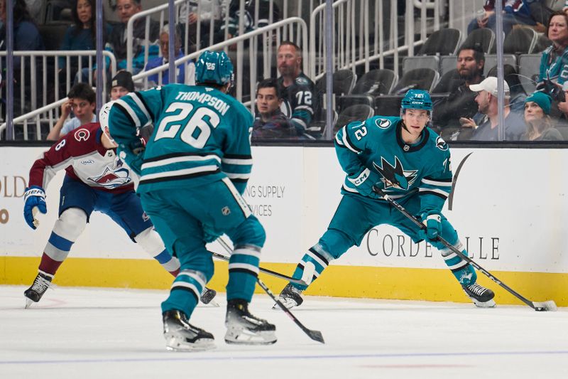 Oct 20, 2024; San Jose, California, USA; San Jose Sharks left wing William Eklund (72) looks to pass the puck to defenseman Jack Thompson (26) against Colorado Avalanche defenseman Cale Makar (8) (obscured) during the first period at SAP Center at San Jose. Mandatory Credit: Robert Edwards-Imagn Images