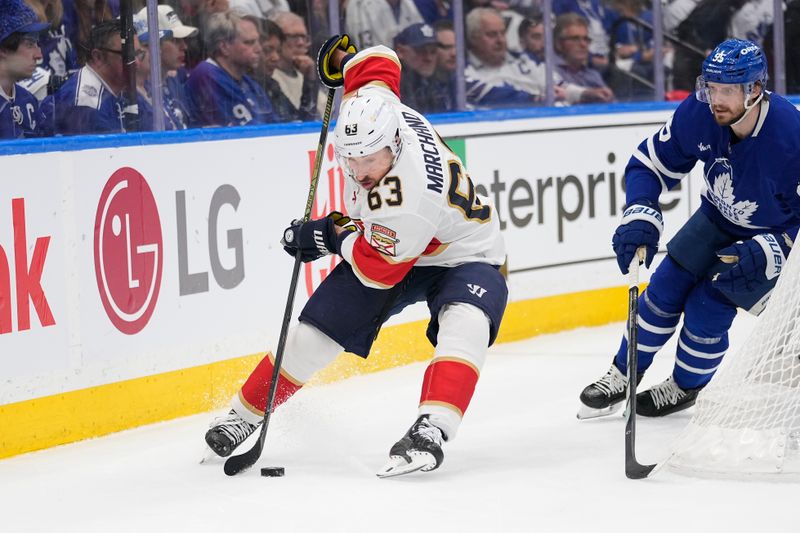 May 18, 2025; Toronto, Ontario, CAN; Florida Panthers forward Brad Marchand (63) controls the puck against Toronto Maple Leafs defenceman Oliver Ekman-Larsson (95) during the second period of game seven of the second round of the 2025 Stanley Cup Playoffs at Scotiabank Arena. Mandatory Credit: John E. Sokolowski-Imagn Images