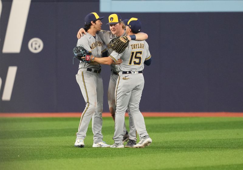 May 31, 2023; Toronto, Ontario, CAN; Milwaukee Brewers left fielder Christian Yelich (22), center fielder Joey Wiemer (28) and right fielder Tyrone Taylor (15) celebrate a win against the Toronto Blue Jays at Rogers Centre. Mandatory Credit: Nick Turchiaro-USA TODAY Sports