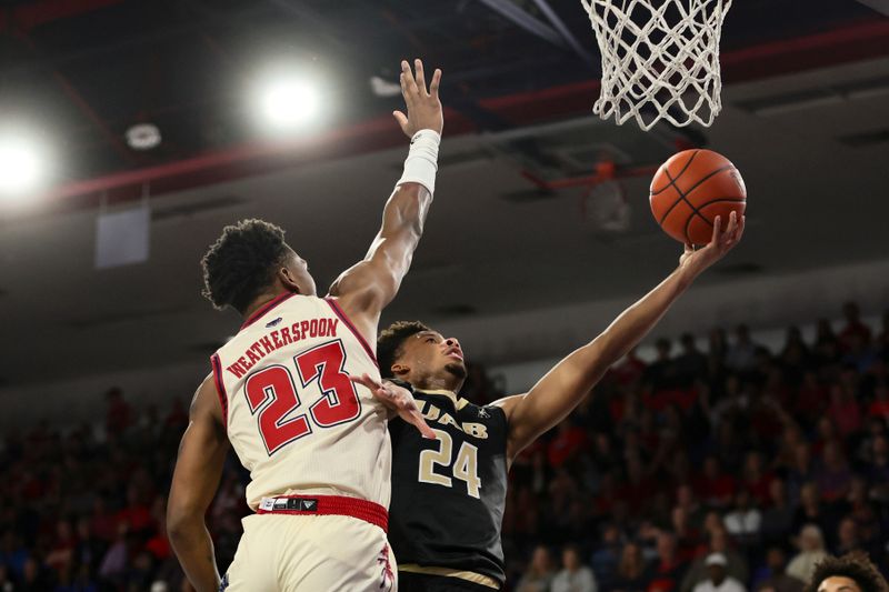 Jan 14, 2024; Boca Raton, Florida, USA; UAB Blazers guard Efrem Johnson (24) drives to the basket against Florida Atlantic Owls guard Brandon Weatherspoon (23) during the first half at Eleanor R. Baldwin Arena. Mandatory Credit: Sam Navarro-USA TODAY Sports