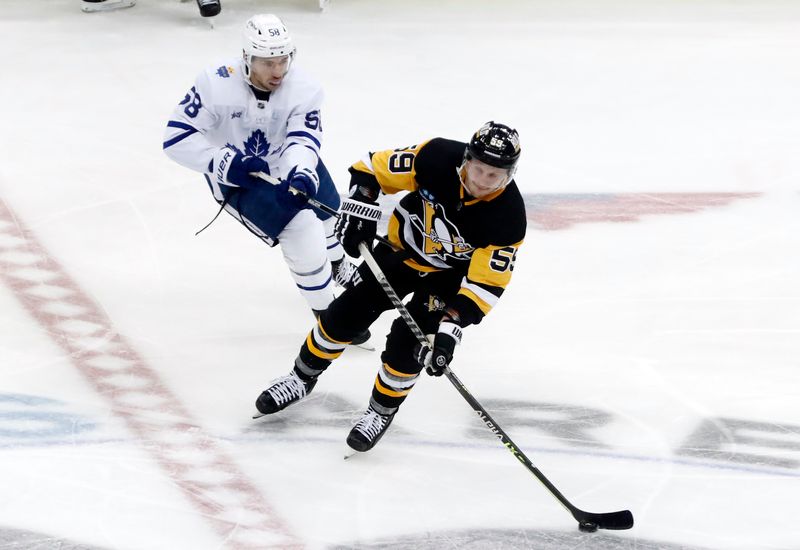 Nov 26, 2022; Pittsburgh, Pennsylvania, USA; Pittsburgh Penguins left wing Jake Guentzel (59) moves the puck against Toronto Maple Leafs left wing Michael Bunting (58) during the third period at PPG Paints Arena. Toronto won 4-1. Mandatory Credit: Charles LeClaire-USA TODAY Sports