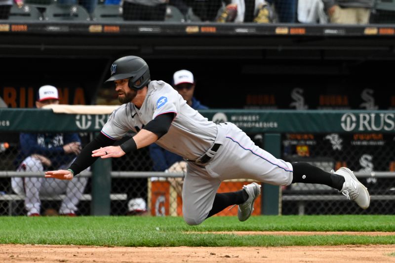 Jun 11, 2023; Chicago, Illinois, USA;  Miami Marlins shortstop Jon Berti (5) leaps into home plate under Chicago White Sox catcher Seby Zavala (44) during the ninth inning at Guaranteed Rate Field. Mandatory Credit: Matt Marton-USA TODAY Sports