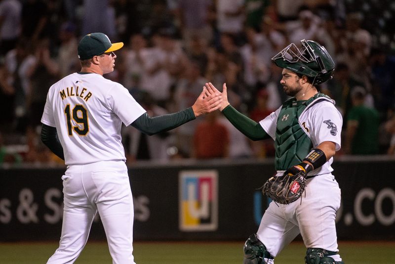 Jul 2, 2024; Oakland, California, USA; Oakland Athletics pitcher Mason Miller (19) and catcher Shea Langeliers (23) celebrate after defeating the Los Angeles Angels at Oakland-Alameda County Coliseum. Mandatory Credit: Ed Szczepanski-USA TODAY Sports