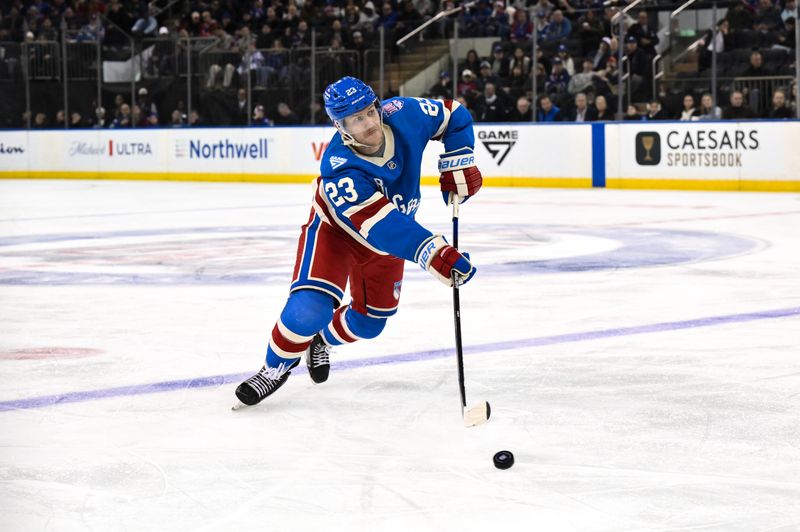 Nov 16, 2025; New York, New York, USA; New York Rangers defenseman Adam Fox (23) passes the puck against the Detroit Red Wings during the third period at Madison Square Garden. Mandatory Credit: John Jones-Imagn Images