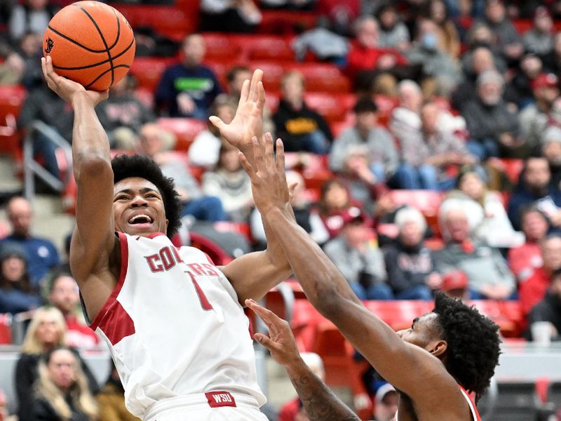 Jan 13, 2024; Pullman, Washington, USA; Washington State Cougars forward Jaylen Wells (0) shoots the ball against Arizona Wildcats guard KJ Lewis (5) in the first half at Friel Court at Beasley Coliseum. Mandatory Credit: James Snook-USA TODAY Sports