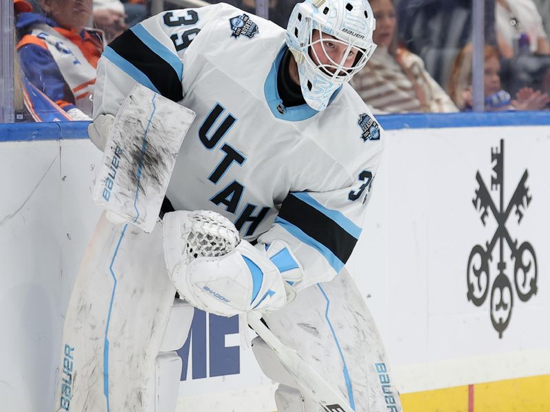 Oct 10, 2024; Elmont, New York, USA; Utah Hockey Club goaltender Connor Ingram (39) controls the puck against the New York Islanders during the second period at UBS Arena. Mandatory Credit: Brad Penner-Imagn Images