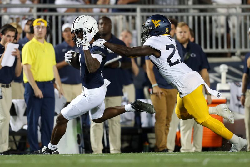 Sep 2, 2023; University Park, Pennsylvania, USA; Penn State Nittany Lions wide receiver KeAndre Lambert-Smith (1) runs with the ball while trying to avoid a tackle from West Virginia Mountaineers safety Keyshawn Cobb (23) during the second quarter at Beaver Stadium. Penn State defeated West Virginia 38-15. Mandatory Credit: Matthew O'Haren-USA TODAY Sports