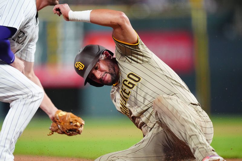 Aug 17, 2024; Denver, Colorado, USA; San Diego Padres outfielder David Peralta (24) reaches third on a error in the sixth inning against the Colorado Rockies at Coors Field. Mandatory Credit: Ron Chenoy-USA TODAY Sports