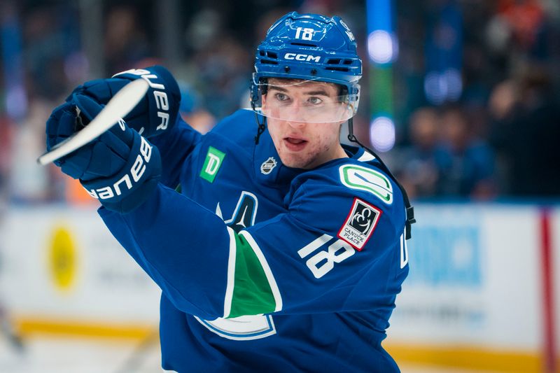 Oct 3, 2025; Vancouver, British Columbia, CAN; Vancouver Canucks forward Drew O'Connor (18) shoots during warm up prior to a game against the Edmonton Oilers at Rogers Arena. Mandatory Credit: Bob Frid-Imagn Images