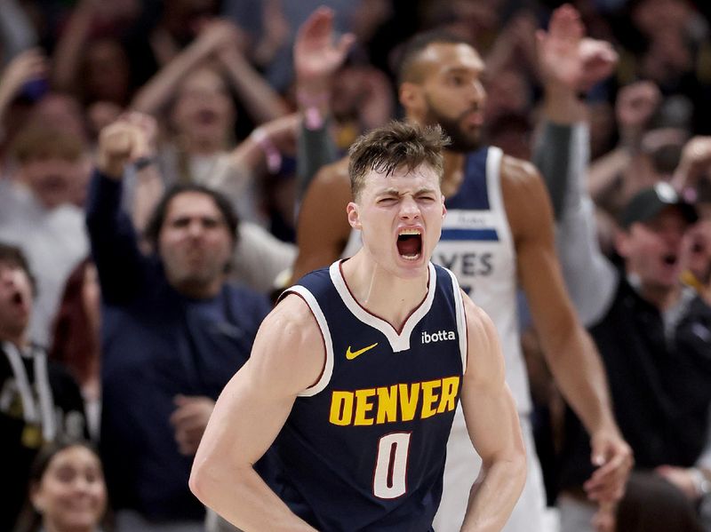 DENVER, COLORADO - APRIL 10: Christian Braun #0 of the Denver Nuggets celebrates after dunking on Rudy Gobert #27 of the Minnesota Timberwolves during the fourth quarter at Ball Arena on April 10, 2024 in Denver, Colorado. NOTE TO USER: User expressly acknowledges and agrees that, by downloading and or using this photograph, User is consenting to the terms and conditions of the Getty Images License Agreement.  (Photo by Matthew Stockman/Getty Images)